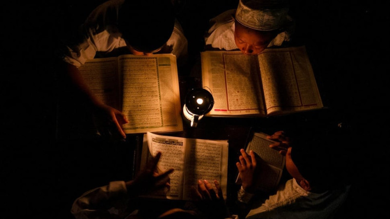 Santri pondok pesantren Baitul Mustofa mengaji dengan penerangan lampu minyak saat pengajian di lapangan terbuka Mojosongo, Solo, Jawa Tengah