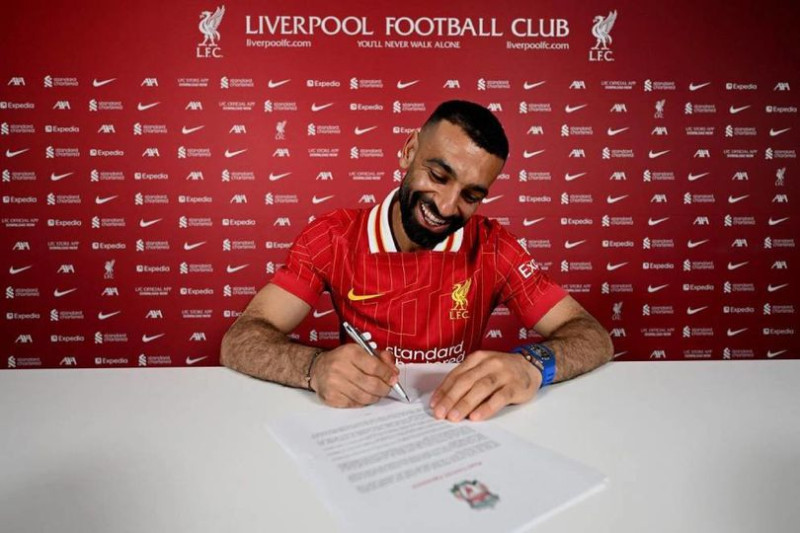 Mohamed Salah saat menandatangani kontrak baru bersama Liverpool.